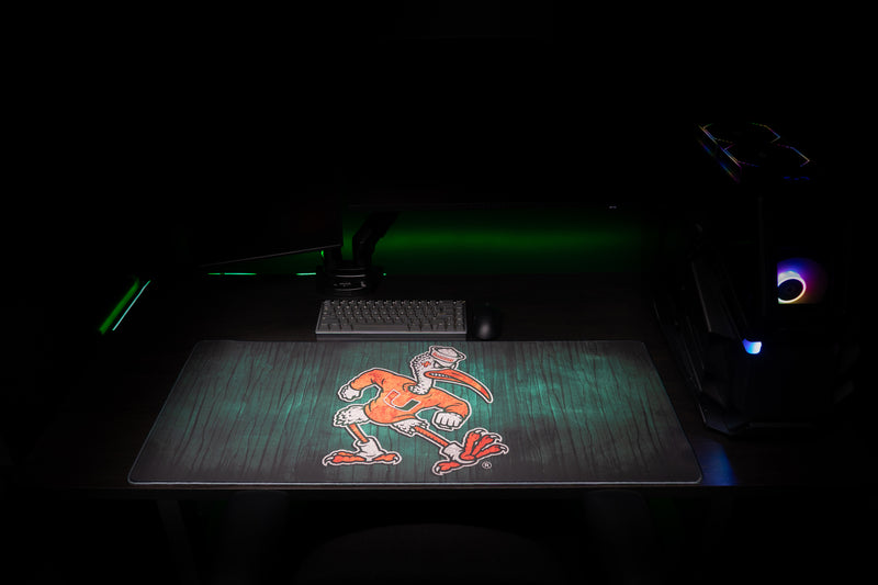 University of Miami Sebastian's Mark deskmat front view of Sebastian across the full dark green wood-grain deskmat