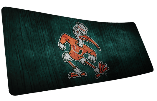 University of Miami Sebastian's Mark deskmat mockup of the running Sebastian ibis mascot over dark green wood grain