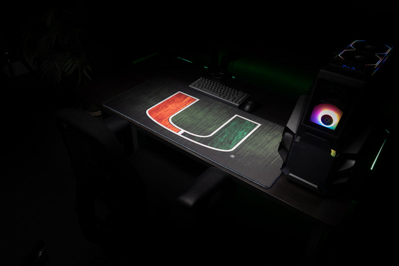 University of Miami The U deskmat angled view of the full U deskmat beside a gaming PC