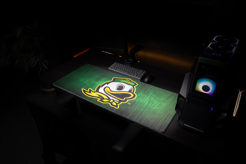 Oregon Duck Country deskmat at an angle across a dark gaming workstation.