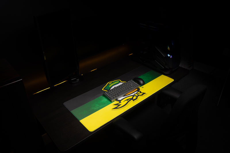 Angled view of the Oregon Duck's Pride deskmat beneath a keyboard.