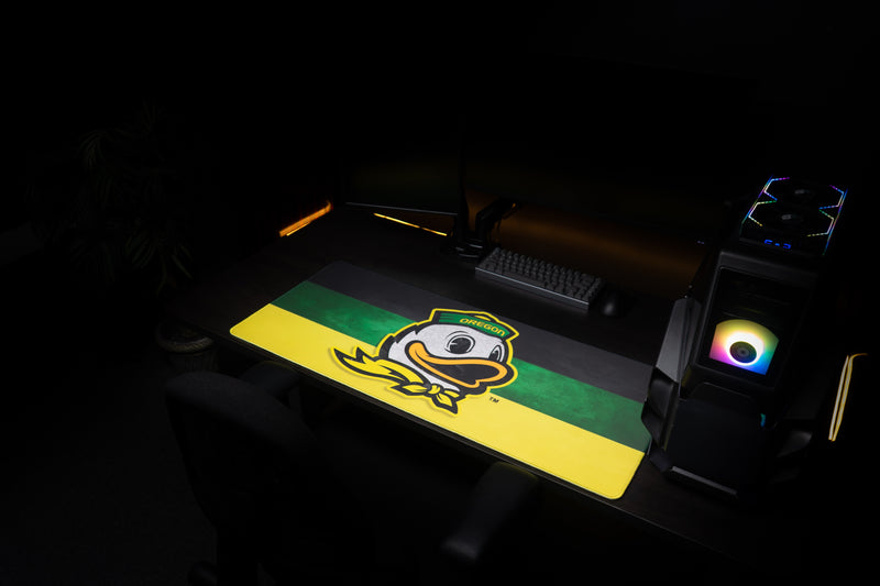 Oregon Duck's Pride deskmat across a dark gaming workstation.