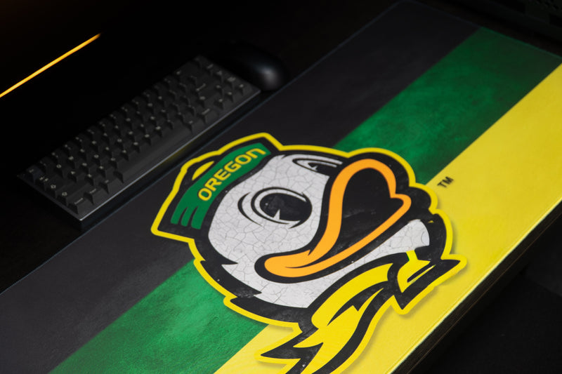 Close-up of the Oregon duck mascot on the green-and-yellow Duck's Pride deskmat.