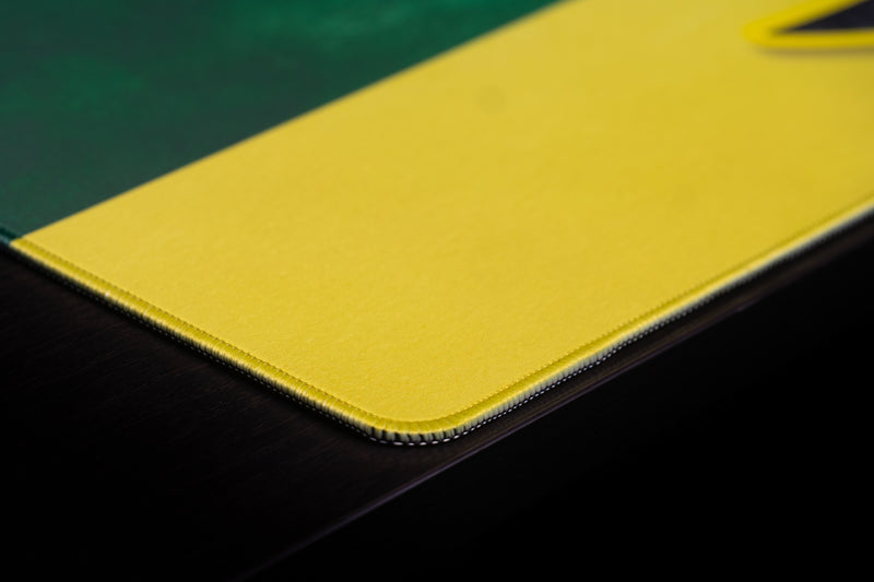 Close-up of the stitched corner and yellow stripe on the Oregon Duck's Pride deskmat.