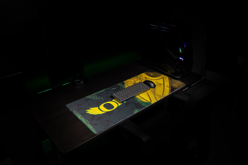 Keyboard and mouse on the Oregon Emerald Flight deskmat with winged O design.