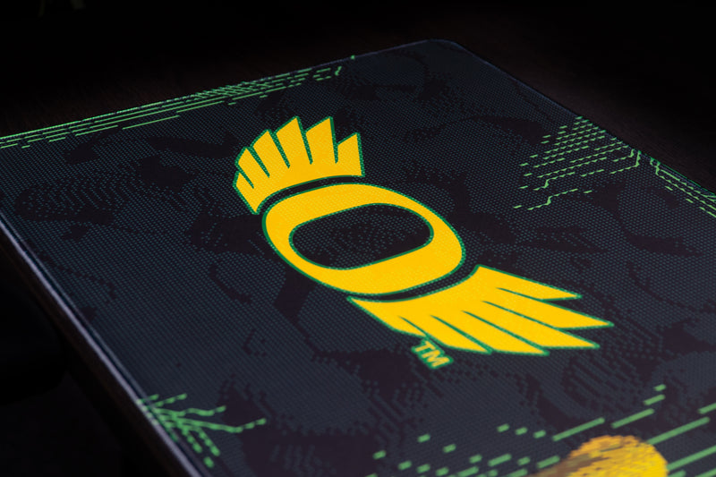 Close-up of the yellow winged O logo on the Oregon Emerald Flight deskmat.
