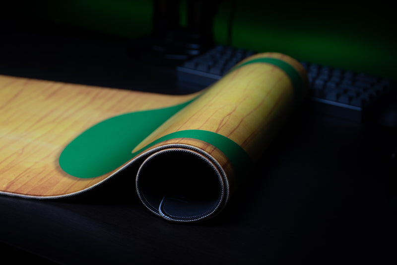 Rolled edge of the Oregon Emerald Grain deskmat showing the green O and stitched border.