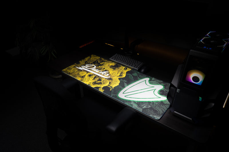 Wide view of the Oregon Emerald Signature deskmat in a dark gaming workstation.