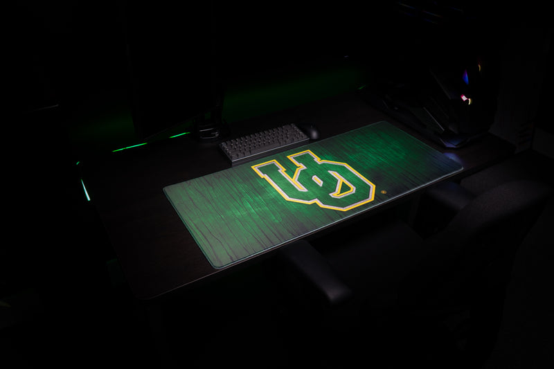Angled view of the Oregon Evergreen deskmat on a dark desktop.