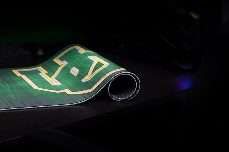 Rolled edge of the Oregon Evergreen deskmat showing its UO logo and stitched border.