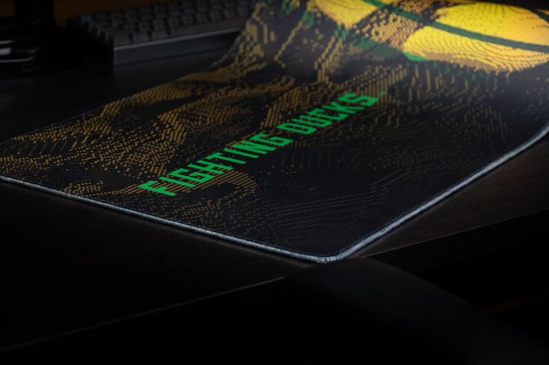 Close-up of the green Fighting Ducks wordmark on the deskmat.