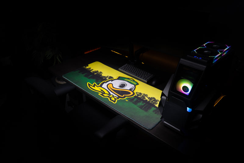 Angled view of the Oregon Home of the Ducks deskmat across a gaming workstation.