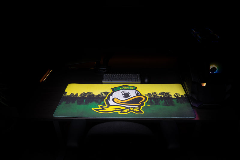 Front view of the Oregon Home of the Ducks deskmat with duck mascot and lake scene.