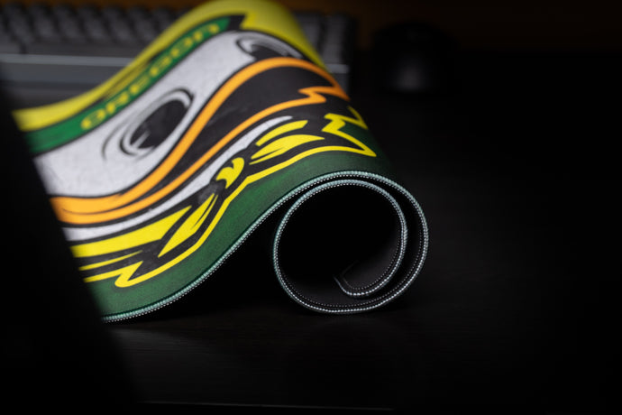 Rolled deskmat edge-on, showing the stitched border and the cushioned 4 mm core