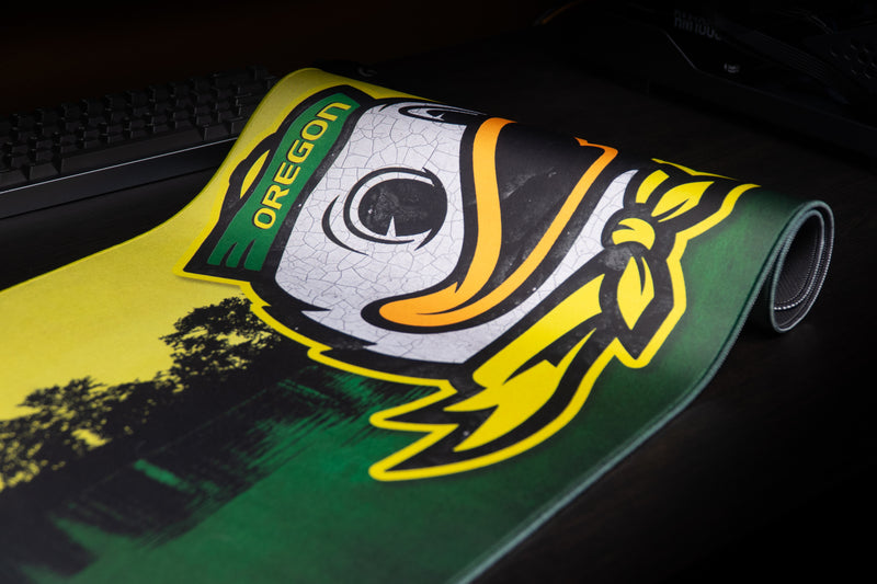 Close-up of the duck mascot on a partly rolled Oregon Home of the Ducks deskmat.