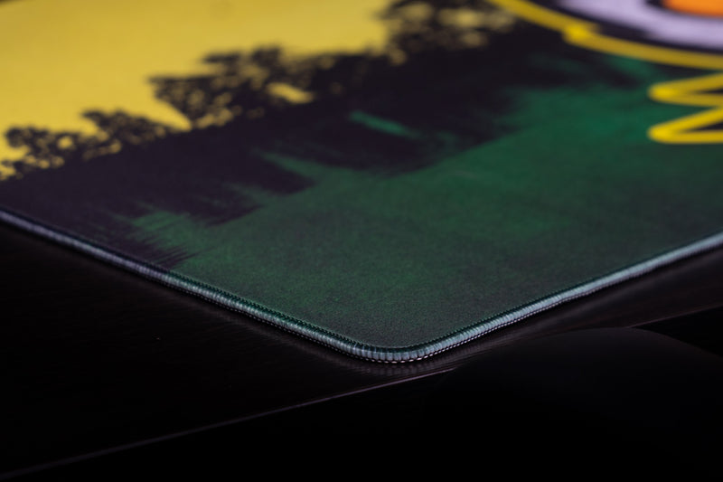 Close-up of the stitched corner and lakeside scene on the Oregon Home of the Ducks deskmat.