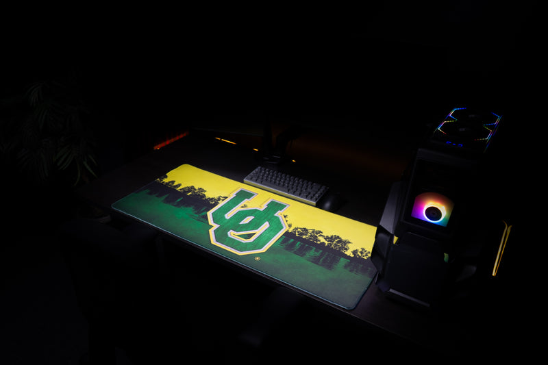 Angled view of the Oregon Horizon in Green deskmat across a gaming workstation.