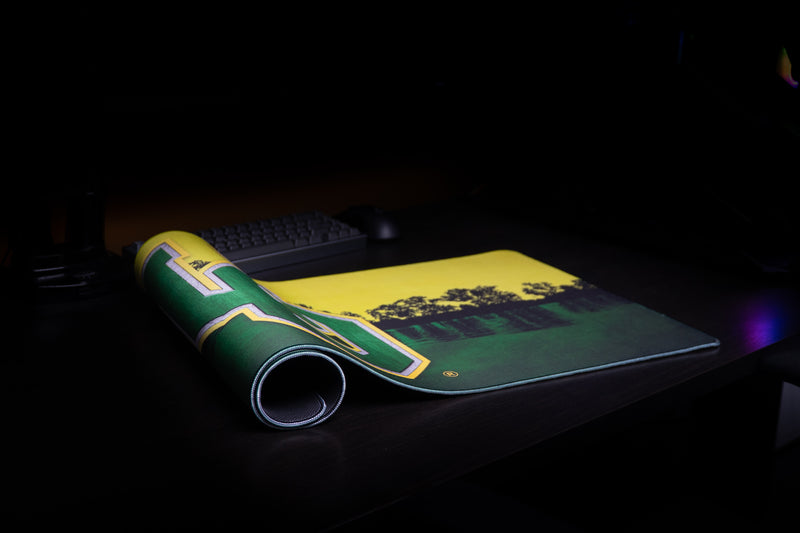 Oregon Horizon in Green deskmat partly rolled on a dark desktop.