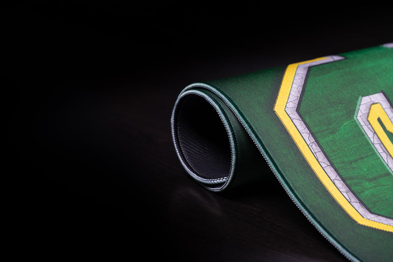 Rolled edge of the Oregon Horizon in Green deskmat showing the UO logo and stitched border.