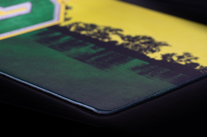 Close-up of the stitched corner and lakeside tree silhouette on the Oregon Horizon in Green deskmat.