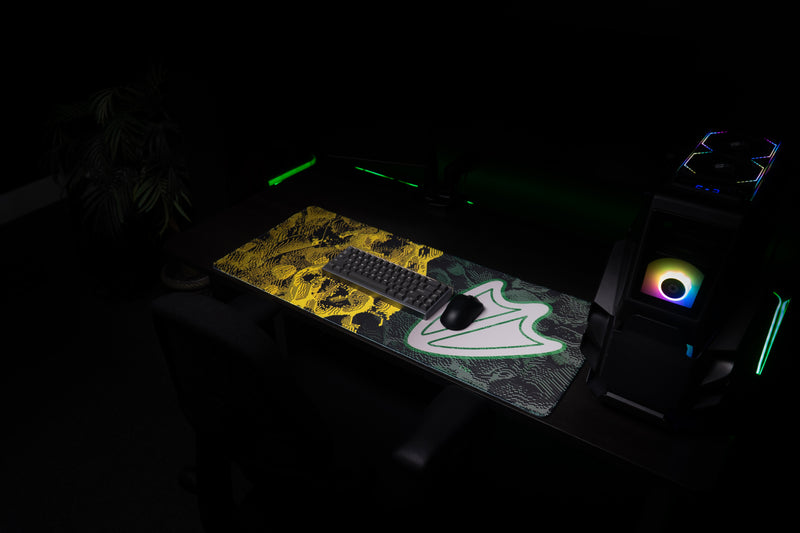 Oregon Flux deskmat across a gaming workstation with yellow-and-green abstract pattern.