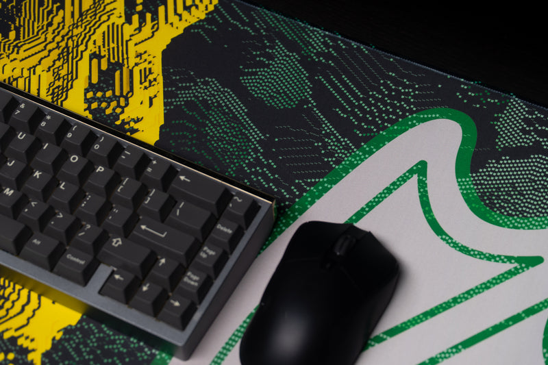Keyboard and mouse over the white webbed-foot emblem on the Oregon Flux deskmat.