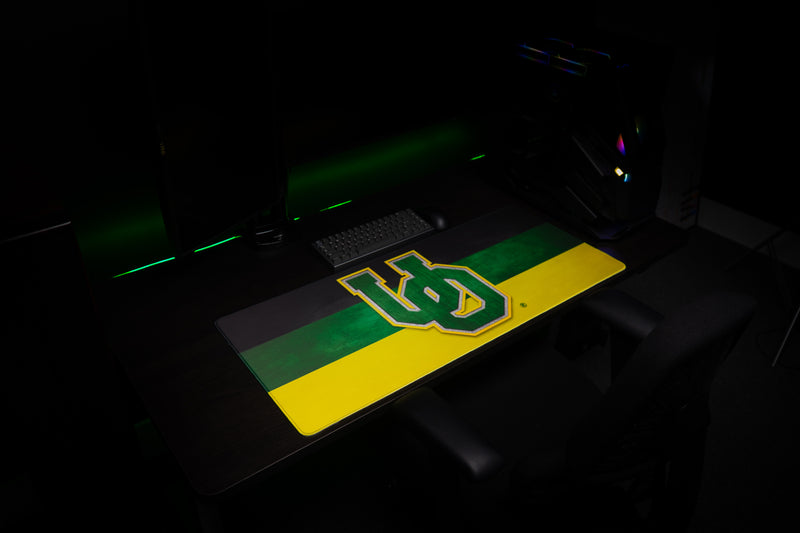 Angled view of the Oregon Pride deskmat across a gaming workstation.