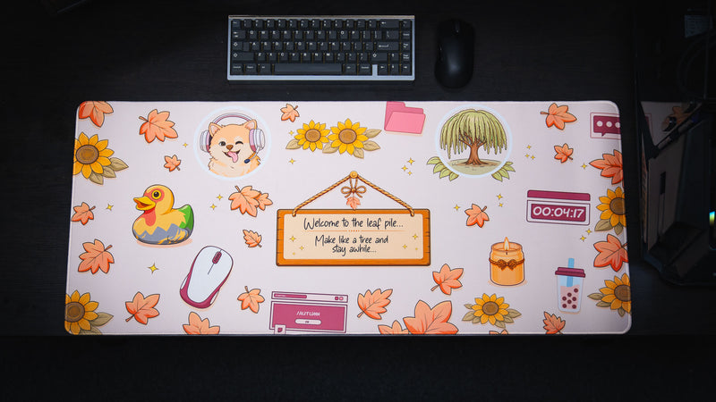 Full view of the Welcome to the Leaf Pile deskmat featuring cozy autumn-themed artwork with falling leaves, sunflowers, a playful duck, and whimsical desktop-inspired illustrations.