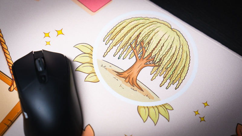 Close-up of the Welcome to the Leaf Pile deskmat highlighting the illustrated willow tree icon with autumn accents and a gaming mouse on the premium cloth surface.