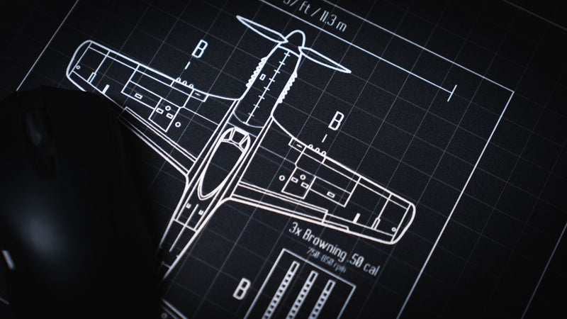 Close-up of the Wings of Liberty P-51D Mustang blueprint deskmat showcasing the top-view aircraft schematic, technical details, and precision-printed drafting grid.