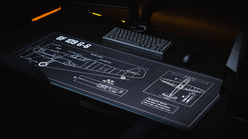 Premium Wings of Steel BF 109 G-6 blueprint deskmat displayed on a gaming workstation with a mechanical keyboard and mouse, showcasing the detailed aircraft engineering schematic across the extended surface.