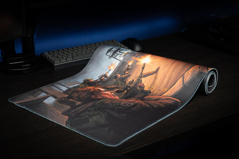 Partially rolled Xclusion Final Stand deskmat showing the survivor battle artwork and stitched edge
