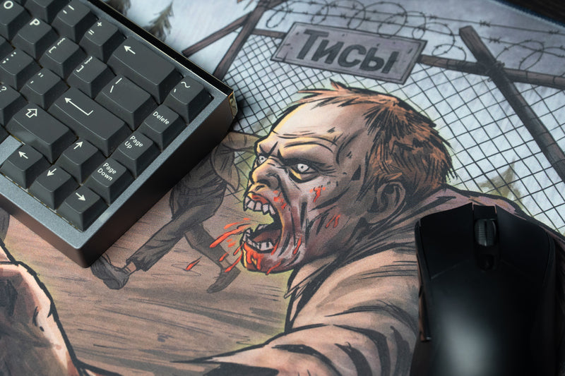 Close-up of a zombie in the Xclusion Final Stand deskmat artwork beside a keyboard and mouse