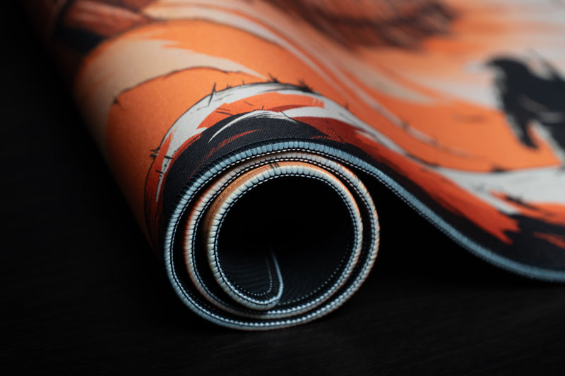Zodec's Great Wall of Chernarus desk mat partly rolled up, showing its flexible build, stitched edges and textured black base